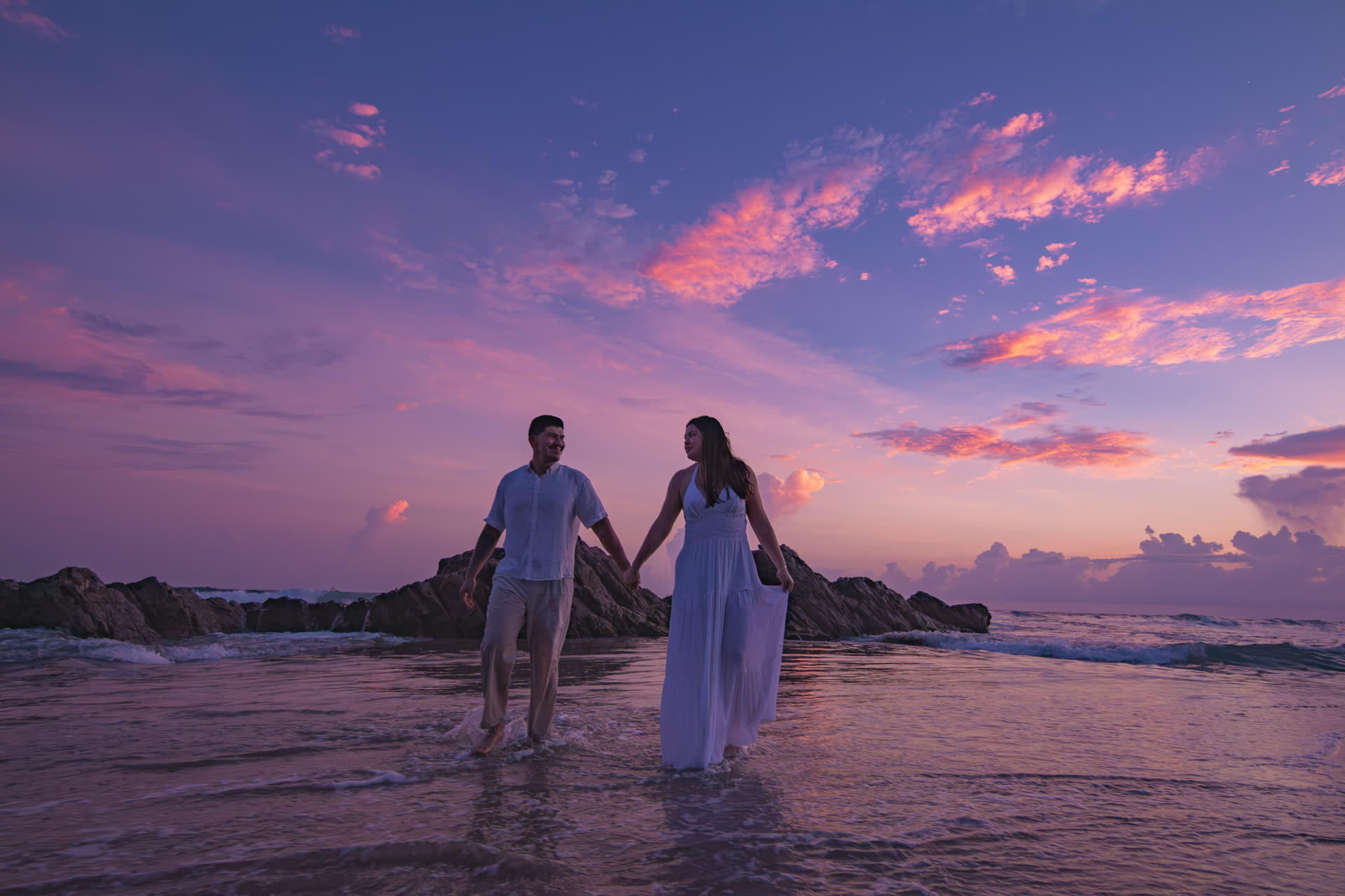 Luisa Crissel y José Manuel caminando en el mar al atardecer